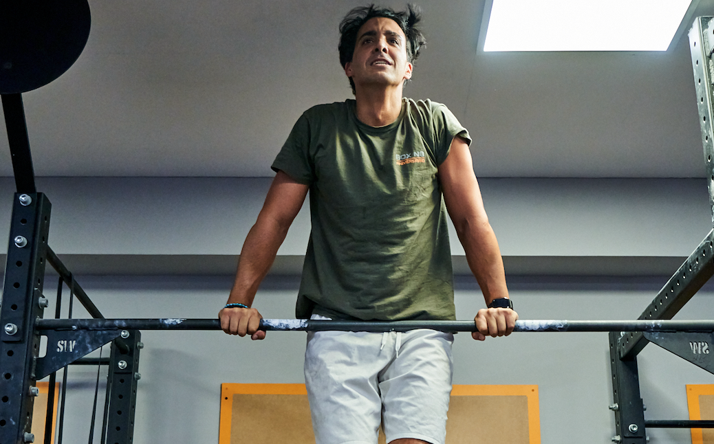 chico haciendo ejercicios de barra en el gimnasio